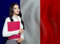 Distance learning in France university concept. Young woman student with French flag background Royalty Free Stock Photo