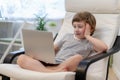 Distance learning online education. Caucasian smile kid boy studying at home with laptop notebook and doing school homework. Royalty Free Stock Photo