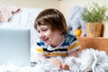 Distance learning online education. Caucasian smile kid boy studying at home with tablet laptop notebook and doing Royalty Free Stock Photo