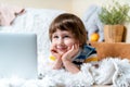 Distance learning online education. Caucasian smile kid boy studying at home with tablet laptop notebook and doing school homework Royalty Free Stock Photo