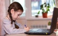 Distance learning online education.School girl does homework on laptop at home.Quarantine Royalty Free Stock Photo