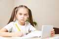 Distance learning online education.School girl does homework on tablet at home. Quarantine Royalty Free Stock Photo