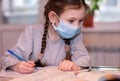 Distance learning online education.School girl in medical mask does homework o at home.Quarantine Royalty Free Stock Photo