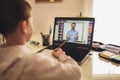 A schoolboy boy studies at home and does school homework. A home distance learning