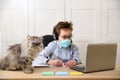 Distance learning online education. schoolboy in medical mask studying at home, working at laptop notebook and doing school Royalty Free Stock Photo