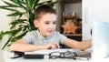 Distance learning online education. A schoolboy is studying at a computer at home and doing school homework. quarantine Royalty Free Stock Photo