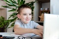 Distance learning online education. A schoolboy is studying at a computer at home and doing school homework. quarantine Royalty Free Stock Photo