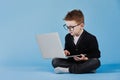 Distance learning online education. Schoolboy studying at home with laptop and doing school homework on blue background Royalty Free Stock Photo