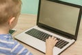 Distance learning online education. Schoolboy studying at home with laptop and doing school homework Royalty Free Stock Photo