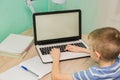 Distance learning online education. Schoolboy studying at home with laptop notebook and doing school homework Royalty Free Stock Photo