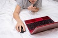 Distance learning online education, schoolboy studying at home while lying in bed with a laptop and doing school homework. e- Royalty Free Stock Photo