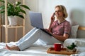 Distance learning online education and work.Happy woman girl working office work remotely from home on bed. Using Royalty Free Stock Photo