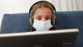 distance learning online a lessons. child girl with digital tablet in mask studying remotely at home. education