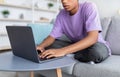 Distance learning. Unrecognizable African American adolescent studying online, using laptop at home, closeup