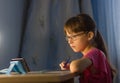 Distance online education. Adorable schoolgirl looks at cellphone