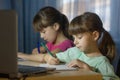 Distance online education. Two schoolgirls study at home and write homework Royalty Free Stock Photo