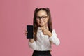 Distance school education. Little pupil in glasses shows on smartphone with blank screen