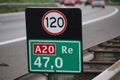 Distance sign at motorway A20 heading gouda with attention sign for speed in kilometers.
