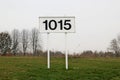 Distance sign for ships in kilometers at 1015 km on river Rhine in the Netherlands.