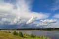 In the distance, thunderclouds are gathering over the river. Royalty Free Stock Photo