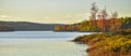 In the distance, two people in a boat. Late summer afternoon, sun shines golden light on a lake. Royalty Free Stock Photo