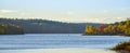 In the distance, two people in a boat. Late summer afternoon, sun shines golden light on a lake. Royalty Free Stock Photo