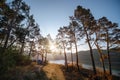 Distance view. Morning landscape. Pine forest, sun rays, glow, river lake, mountains. Summer camping warm colors. Tourism and Royalty Free Stock Photo