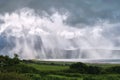 Distance view of a rain storm. Pouring down water over mountains, sun rays, beach. Ring of Kerry, Ireland Royalty Free Stock Photo