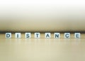 DISTANCE word written in  cube on wooden floor on white background Royalty Free Stock Photo