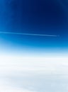 Distant aeroplane flying through blue sky leaving an white jet-stream Royalty Free Stock Photo