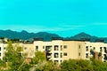 Distant apartment buildings with hazy blue sky background and moutains with copy space available above Royalty Free Stock Photo