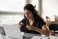 Concentrated female in headset sit by pc support client remotely