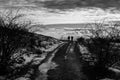 A distant couple on a mountain road, with snow at the sides