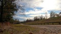 Distant Cyclist lady walking a dogy on a trail