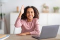 Distant education. Black schoolgirl at laptop raising hand during online school class Royalty Free Stock Photo