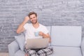 Distant Education. happy male on sofa. guy enjoying internet. social media addiction. computer addict. flirt and send Royalty Free Stock Photo