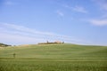 A distant farmhouse on a clear horizon of endless Tuscan hills. Royalty Free Stock Photo