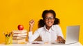 African American School Girl At Laptop Raising Hand, Yellow Background