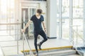 Distant plan of young man going down the stairs at the railway station. Royalty Free Stock Photo