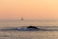 Distant Sailboat and a Rock at Sunset Royalty Free Stock Photo