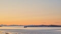 Distant sailboat in the sea near a mountain in the water during sunset. The ocean, beach, or large lake with a marine Royalty Free Stock Photo