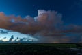 Distant showers and storm clouds over agricultural landscape