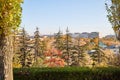 Distant view of the city and houses through the trees in the Park with yellow, green, red leaves. Beautiful autumn landscape Royalty Free Stock Photo