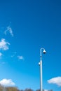 Distant view of a generic CCTV camera seen aloft on a tall metal pole. Royalty Free Stock Photo