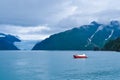 Distant view of a Holgate glacier with red boat in the foreground in Kenai fjords National Park, Seward, Alaska, United States,