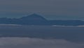 Distant view of island Tenerife with Mount Teide above a sea of clouds viewed from Tamadaba Natural Park, Grand Canaria.