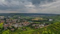 A distant view of landscape, rivers, houses, forest with cloudy sky.