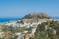 Distant view at Lindos Town and Castle with ancient ruins of the Acropolis on sunny warm day. Island of Rhodes, Greece. Europe Royalty Free Stock Photo