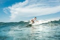 distant view of male surfer riding waves in ocean at Nusa Dua Beach