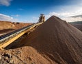 Distant view of a mining conveyor belt transporting heaps of extracted earth